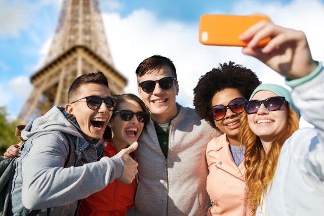 Personas tomándose una selfie frente a la torre eiffel