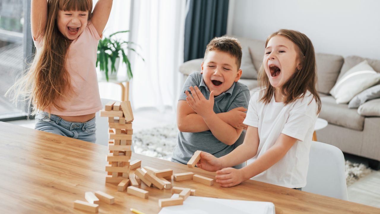 Niños divirtiéndose con un juego gracias a una buena crianza